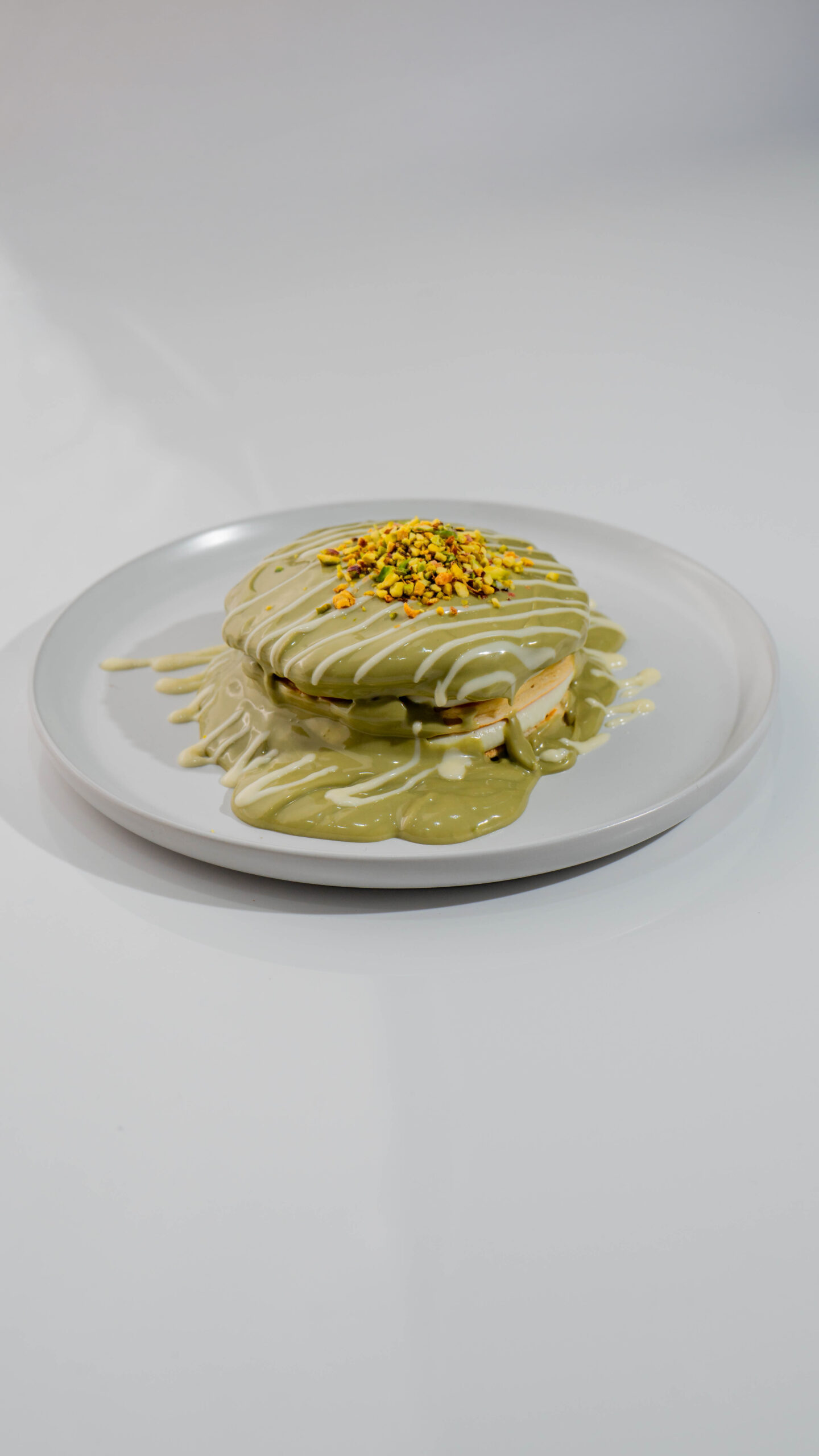 Pistachio pancakes with crushed nuts and syrup